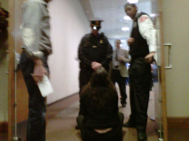 Natasha Loder sitting in front of door at Romney primary event.